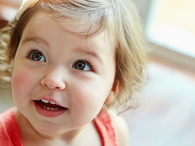 Una bimba piccola sorride alla telecamera