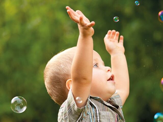 Un bimbo gioca con le bolle di sapone