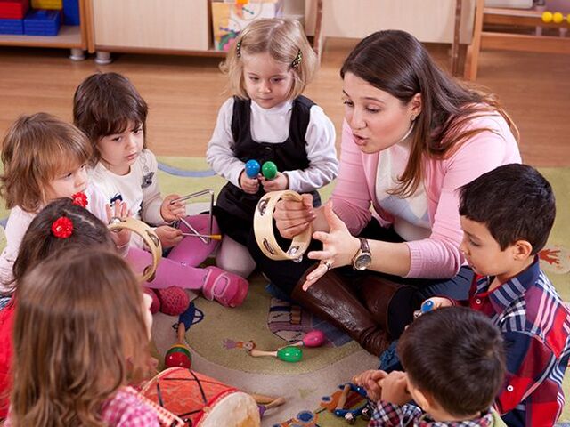 Un gruppo di bimbi e l’educatrice alle prese con la musica all’asilo.