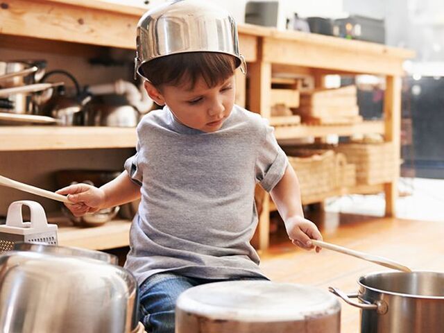Un bimbo suona con degli utensili da cucina