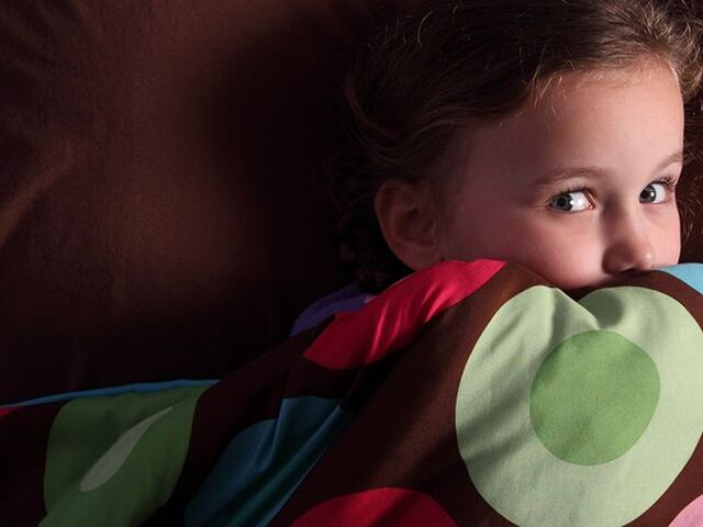 Un bimbo impaurito seduto sul letto.