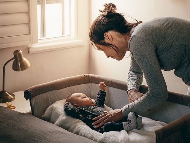 Una mamma porta il suo bambino a letto.
