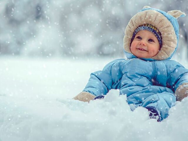 Un bimbo piccolo disteso sulla neve