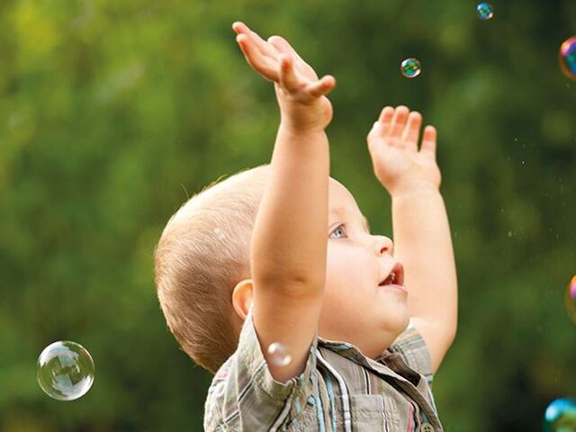 Un bimbo gioca con le bolle di sapone