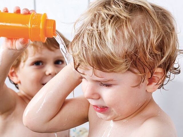 Due bimbi giocano nella vasca da bagno.