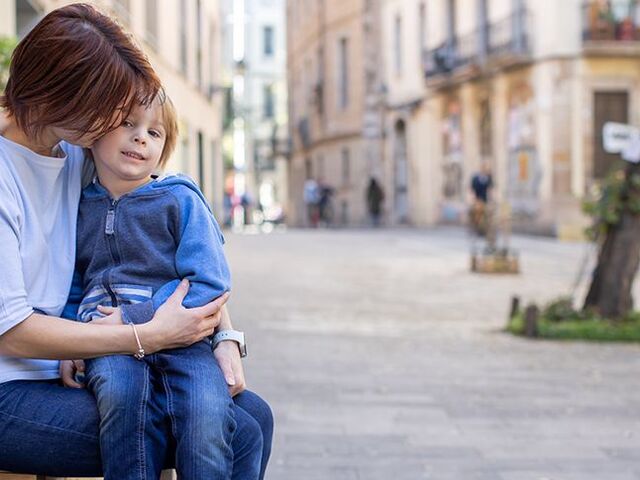 Un bimbo comodamente accoccolato in grembo alla mamma.