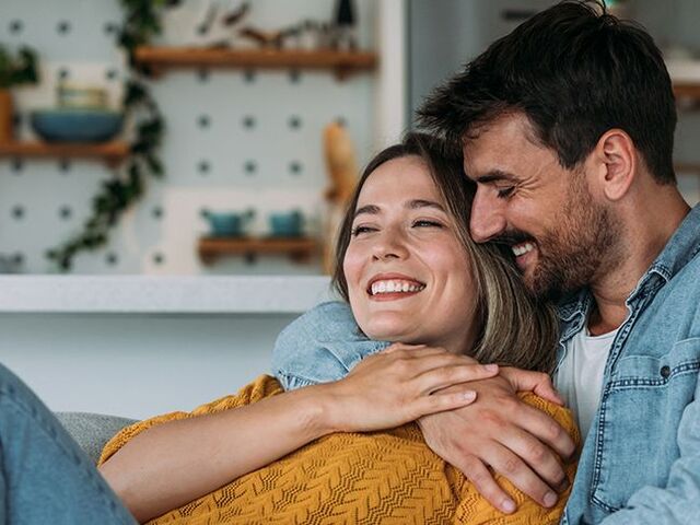 Un uomo e una donna accoccolati sul divano.