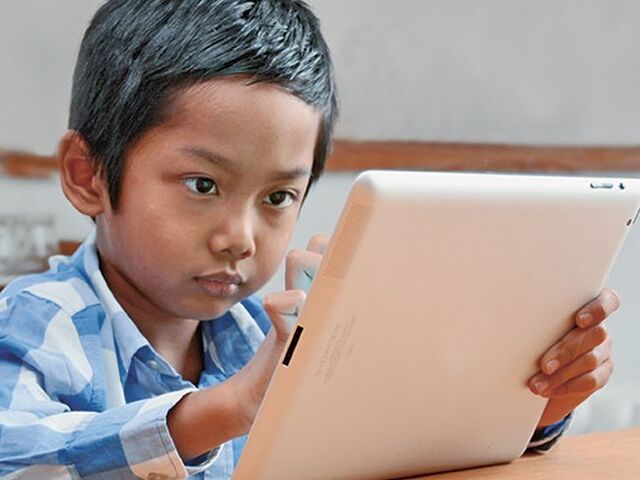 Un bimbo intento a usare un tablet.