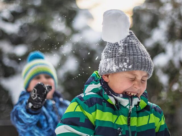Un bimbo tira una palla di neve sulla testa di un coetaneo.