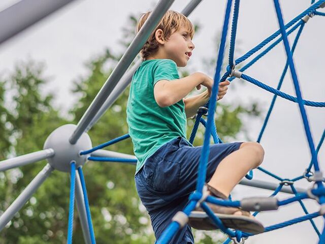 Un bimbo su una struttura per arrampicata.