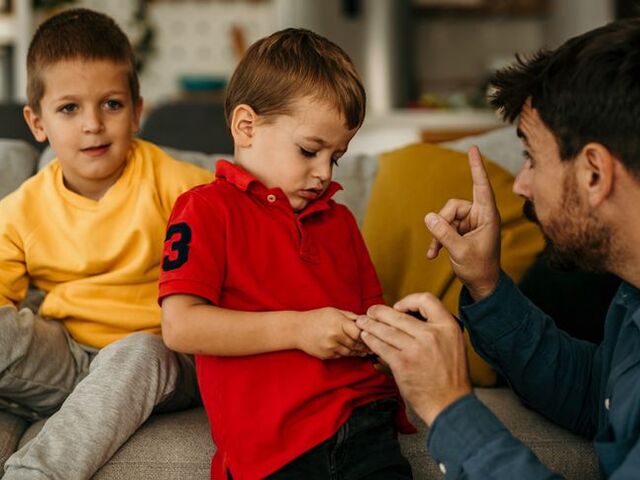Un papà richiama il figlio che ha litigato con il fratello.