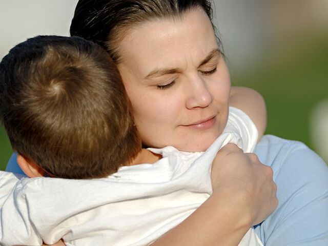 Una mamma e il suo bimbo si abbracciano forte.