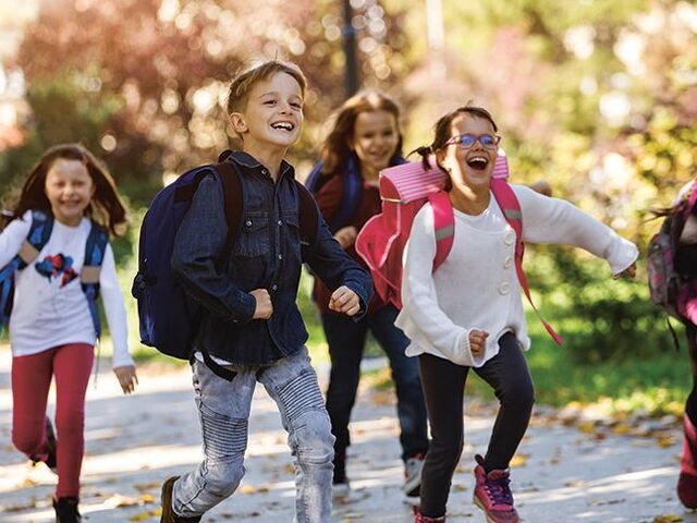 Un gruppo di bimbi corre verso casa dopo la scuola.