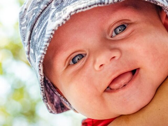 Bebè con cappellino per il sole.