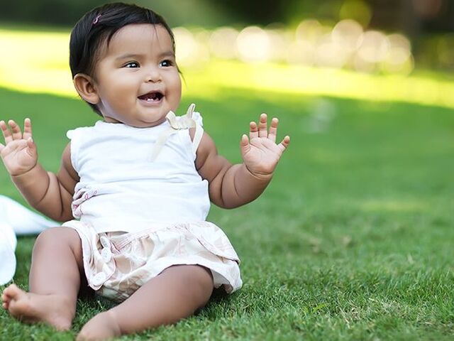 Bambino seduto nell’erba.