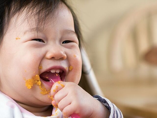 Un bambino mangia allegro la sua pappa.